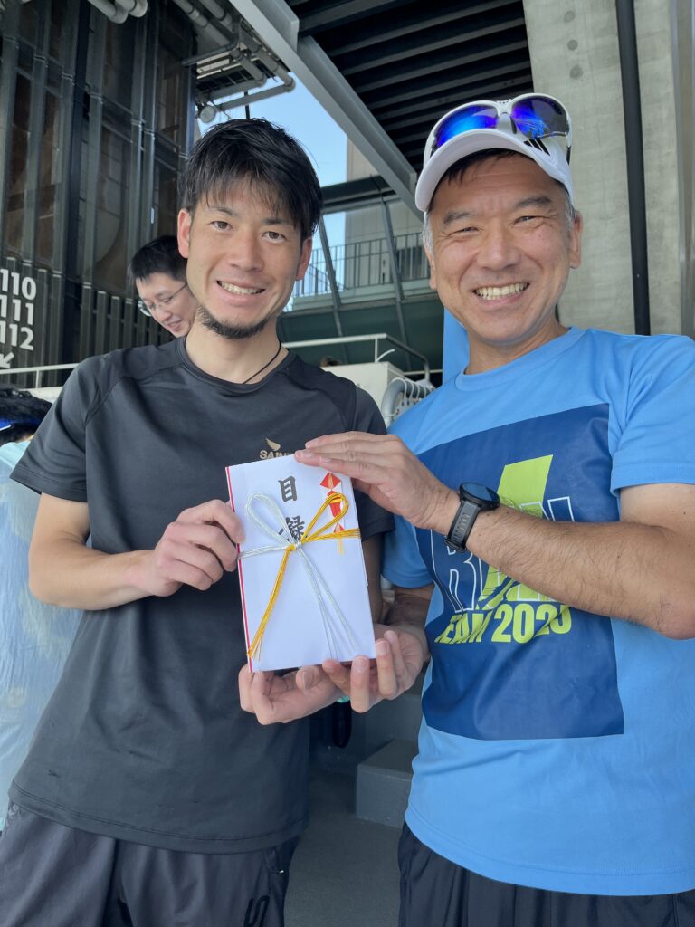 松井俊介氏に目録を渡す高橋啓社長